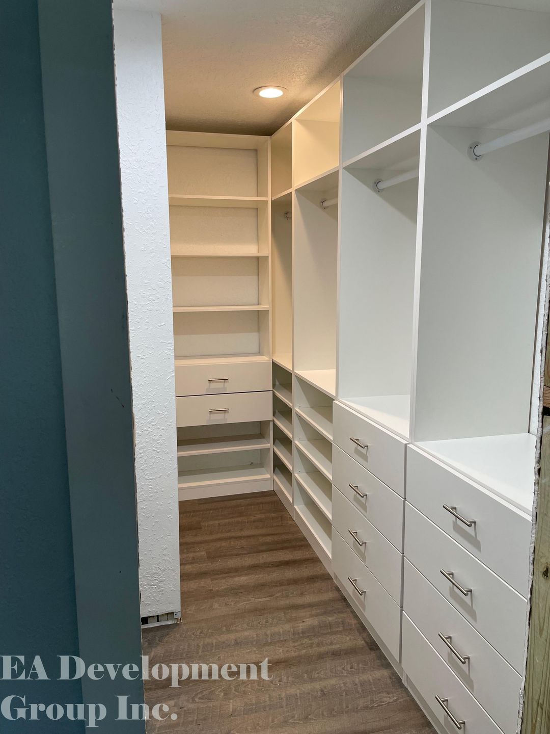 Custom walk-in closet with drawers, shelving, and hanging rods