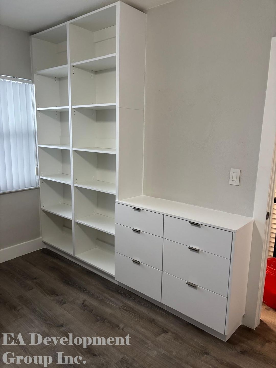 Custom bedroom closet wall unit with open shelving and drawers