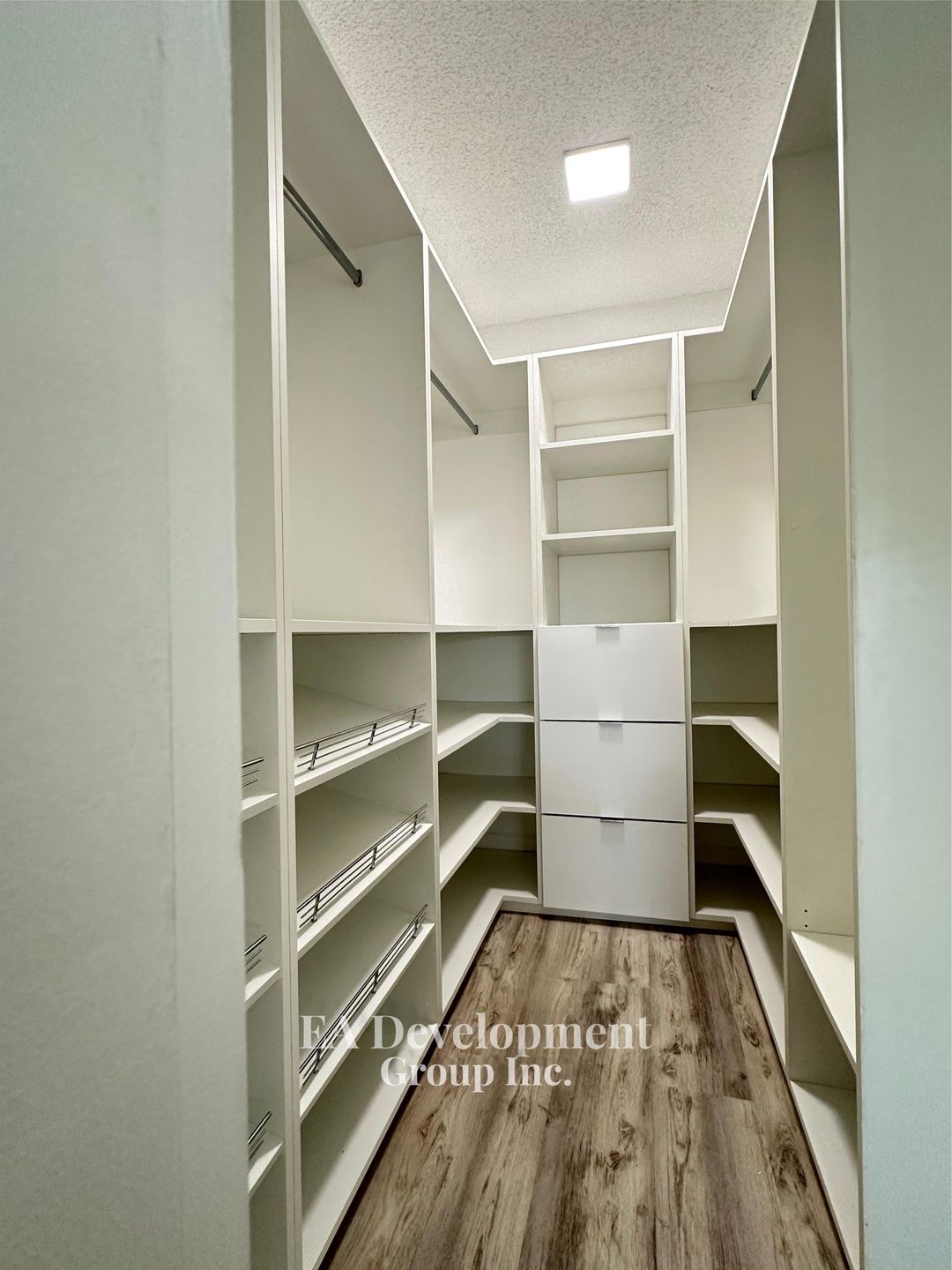 Custom narrow walk-in closet with shoe shelving and drawers