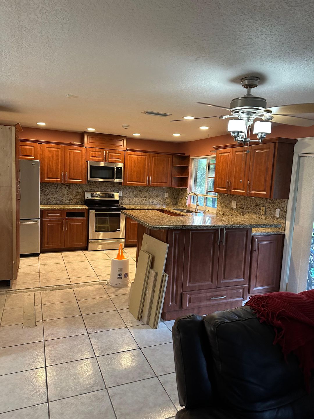 Kitchen renovation before — original cherry cabinetry and granite counters, mid-demo