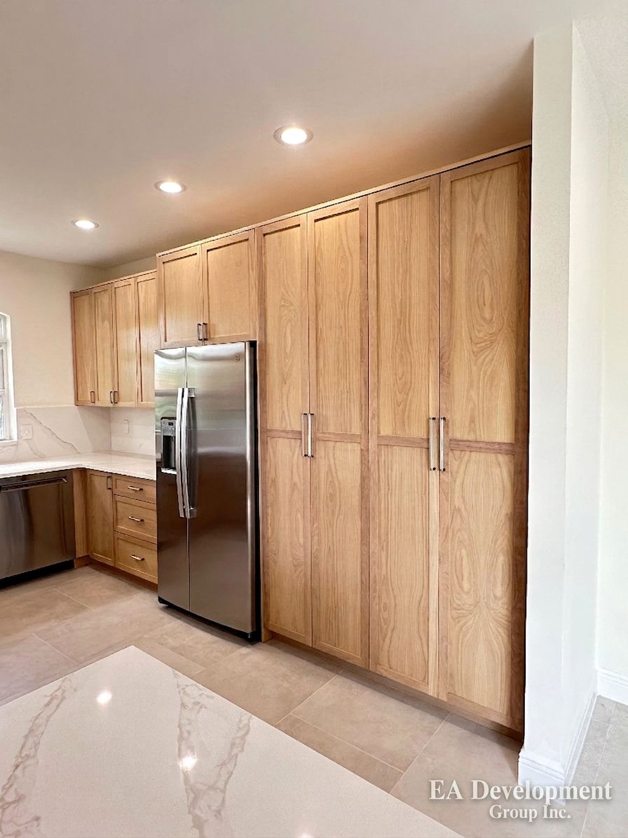 Kitchen renovation after — floor-to-ceiling oak pantry cabinetry