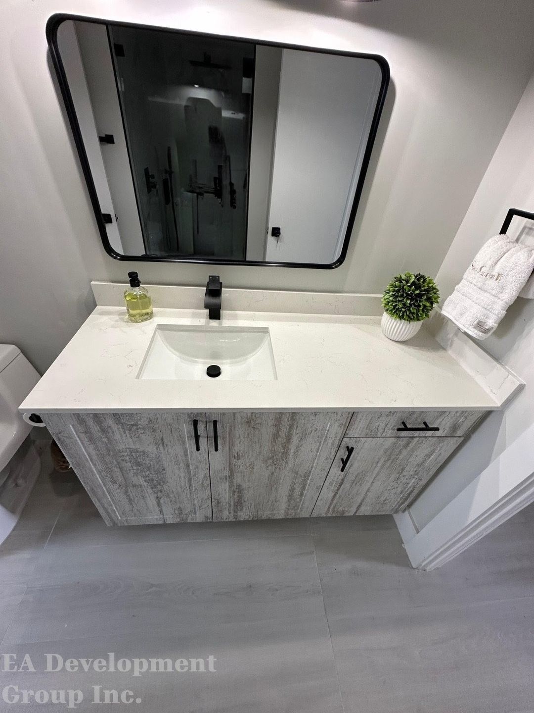 Bathroom renovation after — floating vanity with whitewash finish and black fixtures