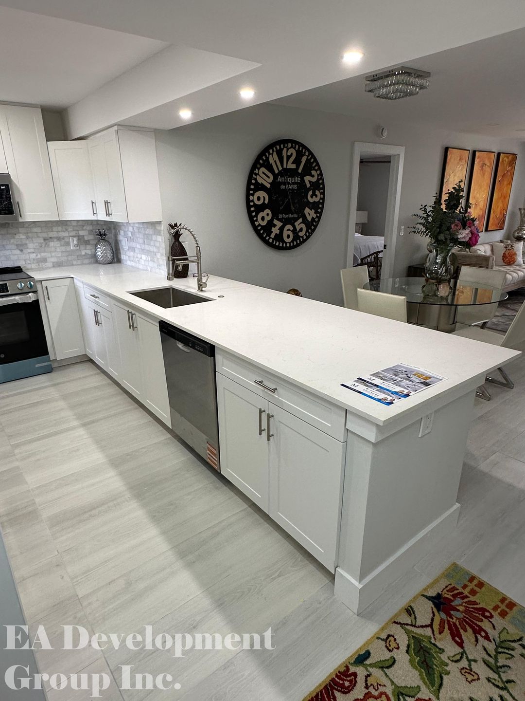 Kitchen renovation after — white cabinetry with quartz island, view 2
