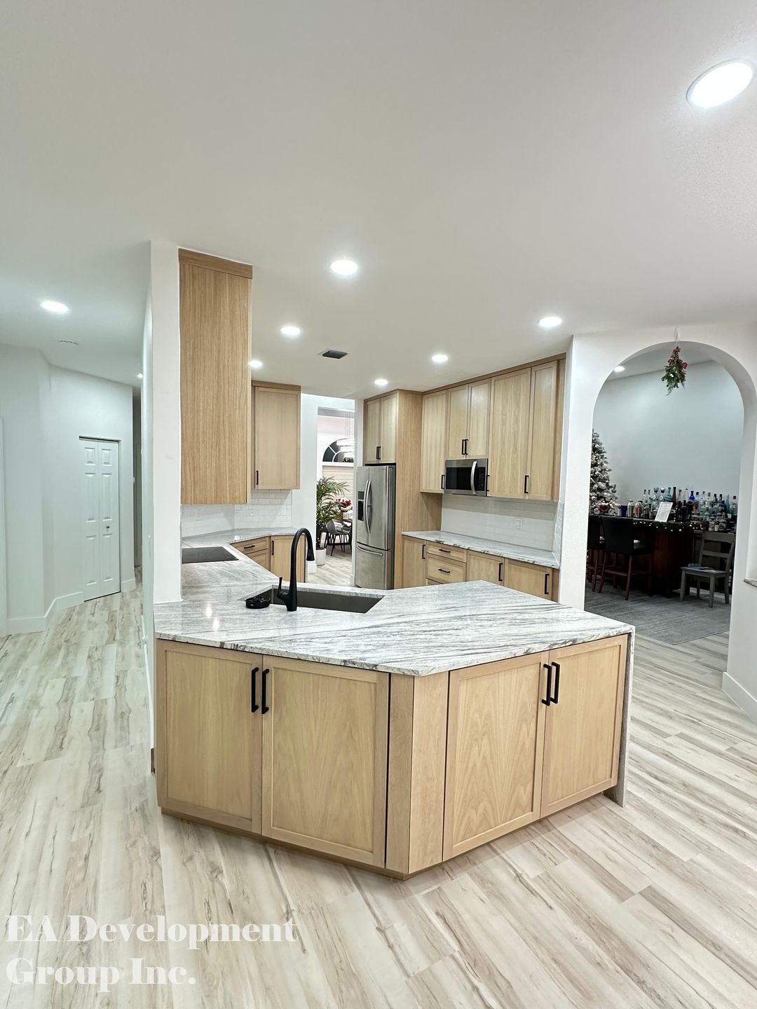 Kitchen renovation after — wide view of oak kitchen open to bar area